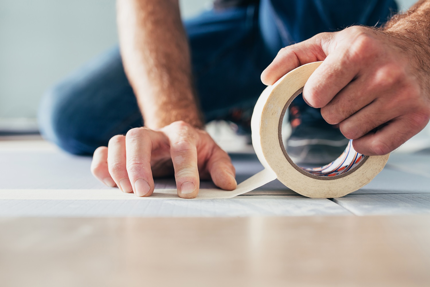 A person applies tape to a surface during a repair or installation job - Cal-West Property Inspections A person applies tape to a surface during a repair or installation job - Cal-West Property Inspections